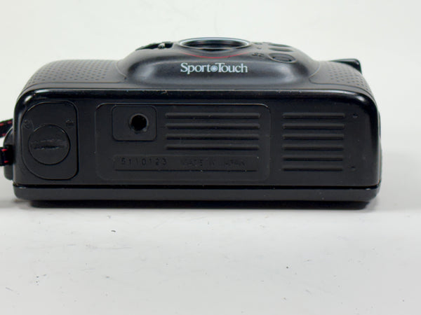Bottom view of Nikon Sport Touch 35mm film camera showing battery compartment and tripod mount, a compact point and shoot model ideal for students.