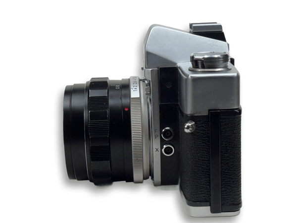 Vintage camera with black lens and silver body on a white background